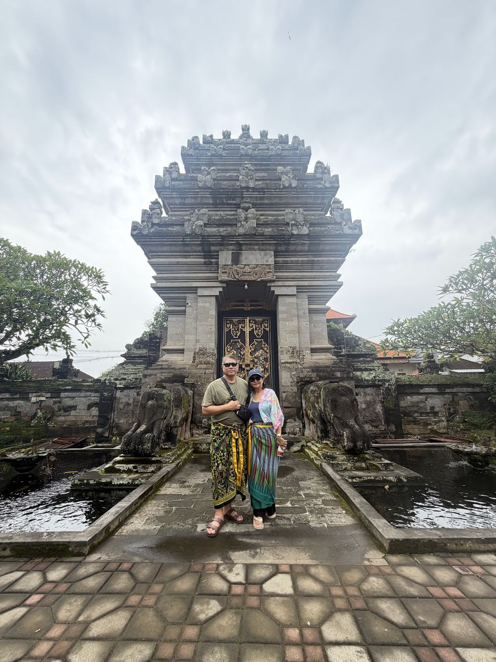A couple in sarongs at a Balinese temple gate on a tour with Awan