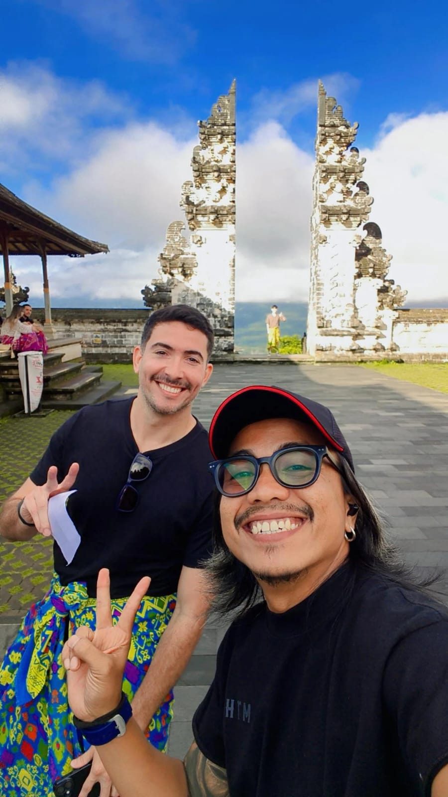 Awan taking a selfie with a guest at a Bali temple gate